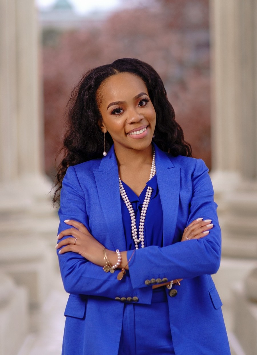 Rosa (RJ) Combs, J.D. smiling with arms crossed on the steps of the U.S. Capitol
